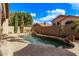 Backyard with a custom pool, rock waterfall, mature landscaping, and privacy wall at 3505 E South Fork Dr, Phoenix, AZ 85044