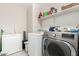 Laundry room with washer, dryer, deep freezer and storage shelves at 36480 W El Greco St, Maricopa, AZ 85138