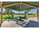 Shaded picnic area with a table and grill, perfect for outdoor dining and gatherings in the community at 36480 W El Greco St, Maricopa, AZ 85138
