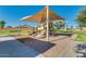 Community playground with covered play structure, slide, and ample recreational space at 36480 W El Greco St, Maricopa, AZ 85138