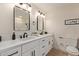 Elegant bathroom featuring double sinks, black fixtures, and modern lighting at 3826 W Davidson Ln, Phoenix, AZ 85051