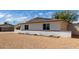 Desert-landscaped home with a white brick wall, with lush greenery on the side yard at 3826 W Davidson Ln, Phoenix, AZ 85051