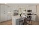 Modern kitchen featuring white cabinetry, stainless steel appliances, and a quartz island with seating at 3826 W Davidson Ln, Phoenix, AZ 85051