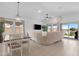 Bright living room boasts a large sectional sofa, tile floors and access to the backyard and lake views at 40365 W Bravo Dr, Maricopa, AZ 85138