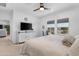 Bright primary bedroom with fan, lake views, TV and ensuite bathroom at 40365 W Bravo Dr, Maricopa, AZ 85138