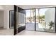 Modern home entryway with pivoting door, floor-to-ceiling windows, and desert landscaping at 5111 E Cortez Dr, Scottsdale, AZ 85254