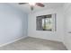 Bright bedroom with light grey wood-look floors, ceiling fan and large window at 5302 E Van Buren St # 2015, Phoenix, AZ 85008