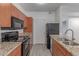 Kitchen with granite countertops, wood cabinets, and black appliances, with a sleek design at 5302 E Van Buren St # 2015, Phoenix, AZ 85008
