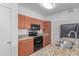 Kitchen featuring granite countertops, wood cabinets, and black appliances at 5302 E Van Buren St # 2015, Phoenix, AZ 85008