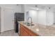 Close-up of the kitchen highlighting granite countertops, stainless steel sink, and modern black appliances at 5302 E Van Buren St # 2015, Phoenix, AZ 85008