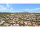 Lovely aerial view of residences in a community setting with manicured landscaping, mountains in the distance and clear blue skies at 5332 S Citrus Ct, Gilbert, AZ 85298