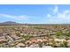 Expansive aerial view of a desert community featuring numerous tile-roofed homes against a backdrop of distant mountains at 5332 S Citrus Ct, Gilbert, AZ 85298