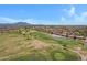 Expansive golf course aerial view with lush greens, serene ponds, and mountain views in the distance at 5332 S Citrus Ct, Gilbert, AZ 85298