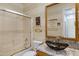 A full bathroom features a glass enclosed shower, stylish sink basin and horizontal striped walls at 5332 S Citrus Ct, Gilbert, AZ 85298