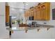 A close up view of the kitchen showcases wood cabinets and granite counters with bar seating at 5332 S Citrus Ct, Gilbert, AZ 85298