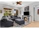 Inviting living room featuring a large sectional, electric fireplace, and a ceiling fan at 5332 S Citrus Ct, Gilbert, AZ 85298