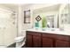 Bright bathroom with a double sink vanity, a large mirror, and a walk-in shower with glass doors, alongside modern fixtures at 7112 N 126Th Ln, Glendale, AZ 85307