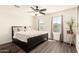 Comfortable bedroom featuring a large bed, ceiling fan, and natural light streaming in through the windows, complemented by wood flooring at 7112 N 126Th Ln, Glendale, AZ 85307