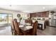 Elegant dining room with ornate table set, flowing to kitchen with stainless steel appliances at 7112 N 126Th Ln, Glendale, AZ 85307