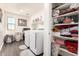 Bright laundry room with modern appliances, ample shelving, and storage space, offering a functional and organized area for chores at 7112 N 126Th Ln, Glendale, AZ 85307