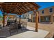 Outdoor pergola with seating and shade, enhancing the backyard living space with a comfortable and inviting atmosphere at 7112 N 126Th Ln, Glendale, AZ 85307