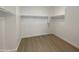 Bright walk-in closet featuring white walls, shelving, and sleek hardwood flooring at 7146 E Bobwhite Ct, San Tan Valley, AZ 85143
