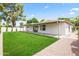 Expansive backyard featuring a covered patio, manicured green lawn, and gravel side yard at 7648 N Via Del Paraiso --, Scottsdale, AZ 85258