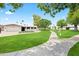 Beautiful single-story home showcasing a lush front lawn, desert landscaping, and a walkway through mature trees at 7648 N Via Del Paraiso --, Scottsdale, AZ 85258