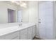 Bright bathroom featuring a large mirror, white cabinets, and access to the patio or outdoors at 8020 W Windrose Dr, Peoria, AZ 85381