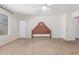 A primary bedroom with carpet, a headboard, a window and access to the back yard at 8020 W Windrose Dr, Peoria, AZ 85381