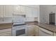 White cabinets, stainless-steel appliances, and an electric range in the open kitchen at 8020 W Windrose Dr, Peoria, AZ 85381