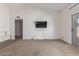 A spacious living room offers carpet floors, a media wall and sliding door to the patio at 8020 W Windrose Dr, Peoria, AZ 85381