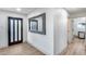 Welcoming entryway with modern mirror and stylish wood-look flooring and a dark, glass-paneled front door at 8117 E Lewis Ave, Scottsdale, AZ 85257