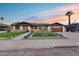 Stylish home displaying a neatly landscaped front yard and welcoming facade with a beautiful sunset backdrop at 8117 E Lewis Ave, Scottsdale, AZ 85257
