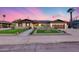 Charming single-story home with an inviting front yard, lush landscaping, and a two-car garage at 8117 E Lewis Ave, Scottsdale, AZ 85257