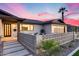 Charming home featuring a decorative concrete block fence, desert landscaping and a stunning sunset sky at 8117 E Lewis Ave, Scottsdale, AZ 85257