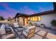 Inviting front patio with seating, modern fire pit, stylish pavers, manicured landscaping, and a welcoming entrance at 8117 E Lewis Ave, Scottsdale, AZ 85257