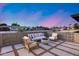 Inviting front patio featuring comfortable seating, a modern fire pit, pavers, and stylish landscaping at 8117 E Lewis Ave, Scottsdale, AZ 85257