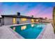 Backyard swimming pool reflecting the glowing sky and surrounding landscape at twilight at 8117 E Lewis Ave, Scottsdale, AZ 85257