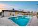 A refreshing swimming pool with stone tile surround is the focal point of this backyard at 8117 E Lewis Ave, Scottsdale, AZ 85257