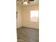 Bright bedroom with ceiling fan, gray wood-look floors, and natural light from a window at 930 W Mackenzie Dr, Phoenix, AZ 85013
