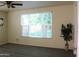Bedroom with large window showing greenery, fan, and light-colored flooring at 930 W Mackenzie Dr, Phoenix, AZ 85013
