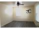 Bright bedroom with gray wood-look flooring, fan, and picture on the wall at 930 W Mackenzie Dr, Phoenix, AZ 85013