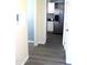 Hallway to kitchen with stainless steel refrigerator, white cabinets and gray counter tops at 930 W Mackenzie Dr, Phoenix, AZ 85013