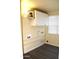 Bright laundry room offers vinyl floors, white cabinets and convenient shelving at 930 W Mackenzie Dr, Phoenix, AZ 85013