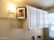 Bright laundry room with overhead cabinets, shelving, and utility connections at 930 W Mackenzie Dr, Phoenix, AZ 85013