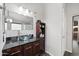 Bathroom features a modern glass vessel sink, granite counters and warm wood cabinet at 11840 N 59Th Ln, Glendale, AZ 85304