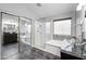 Spacious bathroom showcasing glass enclosed shower, soaking tub and dual glass vessel sinks at 11840 N 59Th Ln, Glendale, AZ 85304