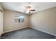 Cozy bedroom with neutral carpet and walls, natural light from the window, and a ceiling fan at 11840 N 59Th Ln, Glendale, AZ 85304