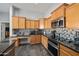 Bright kitchen with maple cabinets, tile backsplash, and stainless steel appliances at 11840 N 59Th Ln, Glendale, AZ 85304